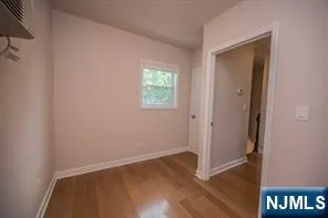 an empty room with wooden floor and a window