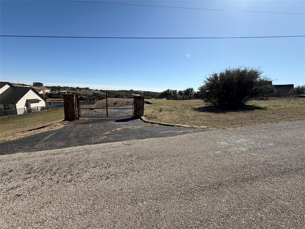 7037 Hells Gate Loop Strawn, TX 76475 - Photo 2 of 10 a view of a dry yard with wooden fence