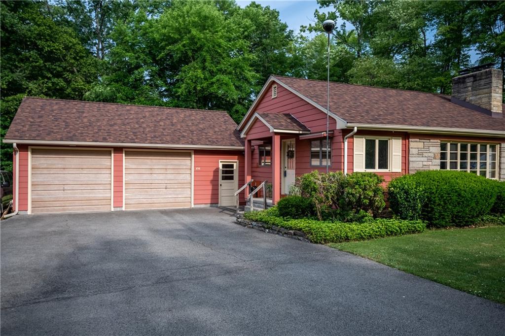 a front view of a house with a garden and plants