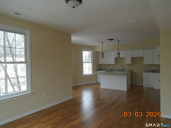a kitchen with granite countertop white cabinets and wooden floor
