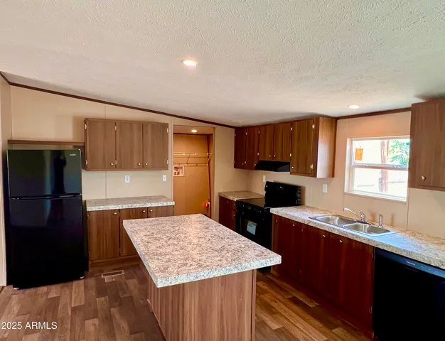a kitchen with stainless steel appliances kitchen island granite countertop a stove and a refrigerator