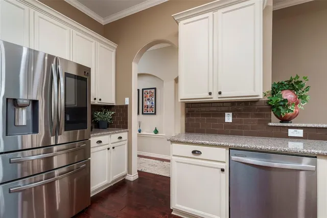 a kitchen with granite countertop white cabinets and stainless steel appliances