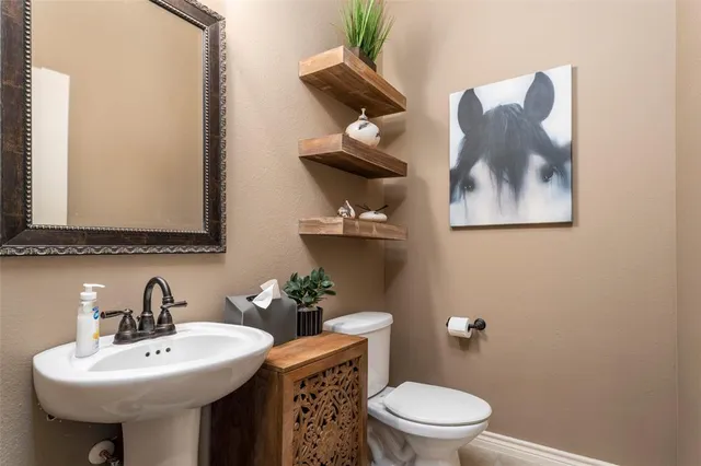 a bathroom with a toilet a sink and mirror