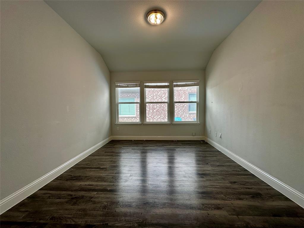 1223 Mount Olive Lane Forney, TX 75126 - Photo 14 of 28 Empty room with vaulted ceiling and dark wood finished floors