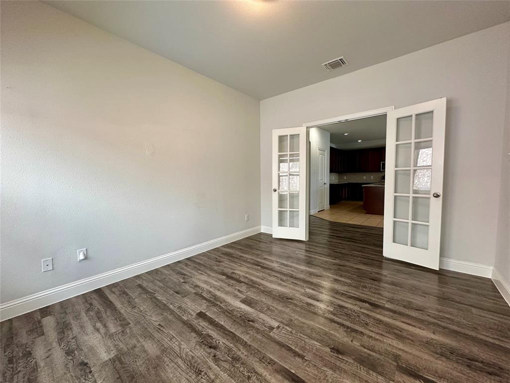 1223 Mount Olive Lane Forney, TX 75126 - Photo 15 of 28 Empty room featuring french doors and dark wood-style floors