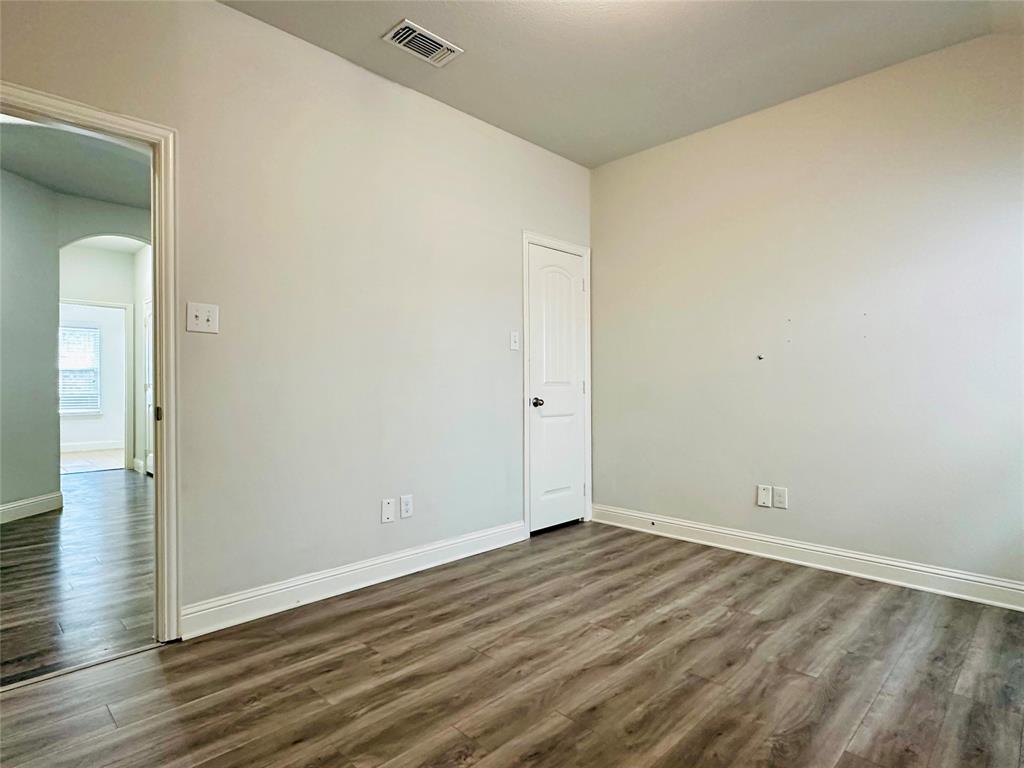 1223 Mount Olive Lane Forney, TX 75126 - Photo 6 of 28 Empty room with arched walkways and dark wood finished floors