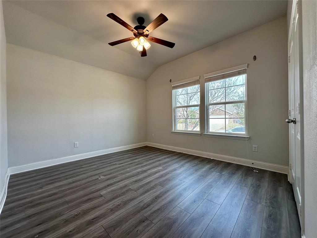 1223 Mount Olive Lane Forney, TX 75126 - Photo 8 of 28 Unfurnished room featuring dark wood-style floors, a ceiling fan, and vaulted ceiling