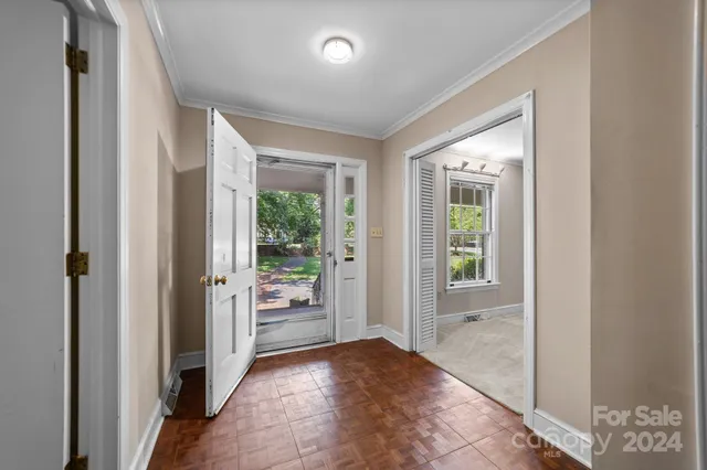 a view of a hallway with windows and a livingroom