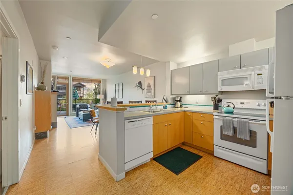 a kitchen with stainless steel appliances granite countertop a refrigerator stove oven and white cabinets with wooden floor