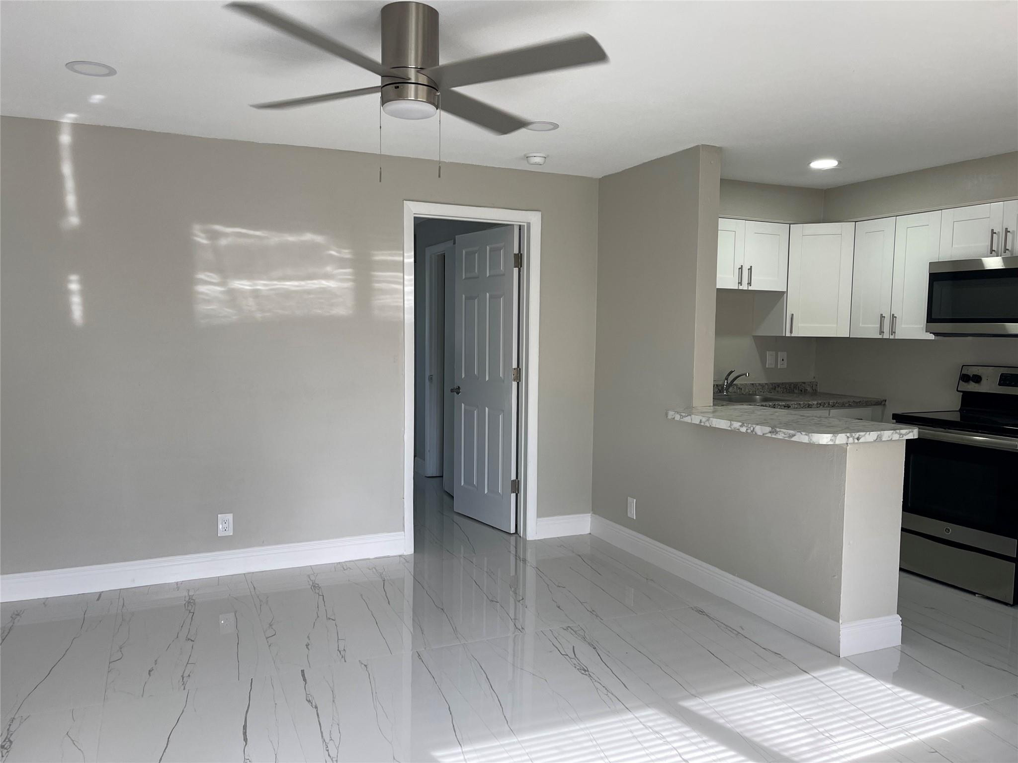 721 Southwest 8th Street Pompano Beach, FL 33060 - Photo 13 of 21 a kitchen with granite countertop a refrigerator and a stove top oven