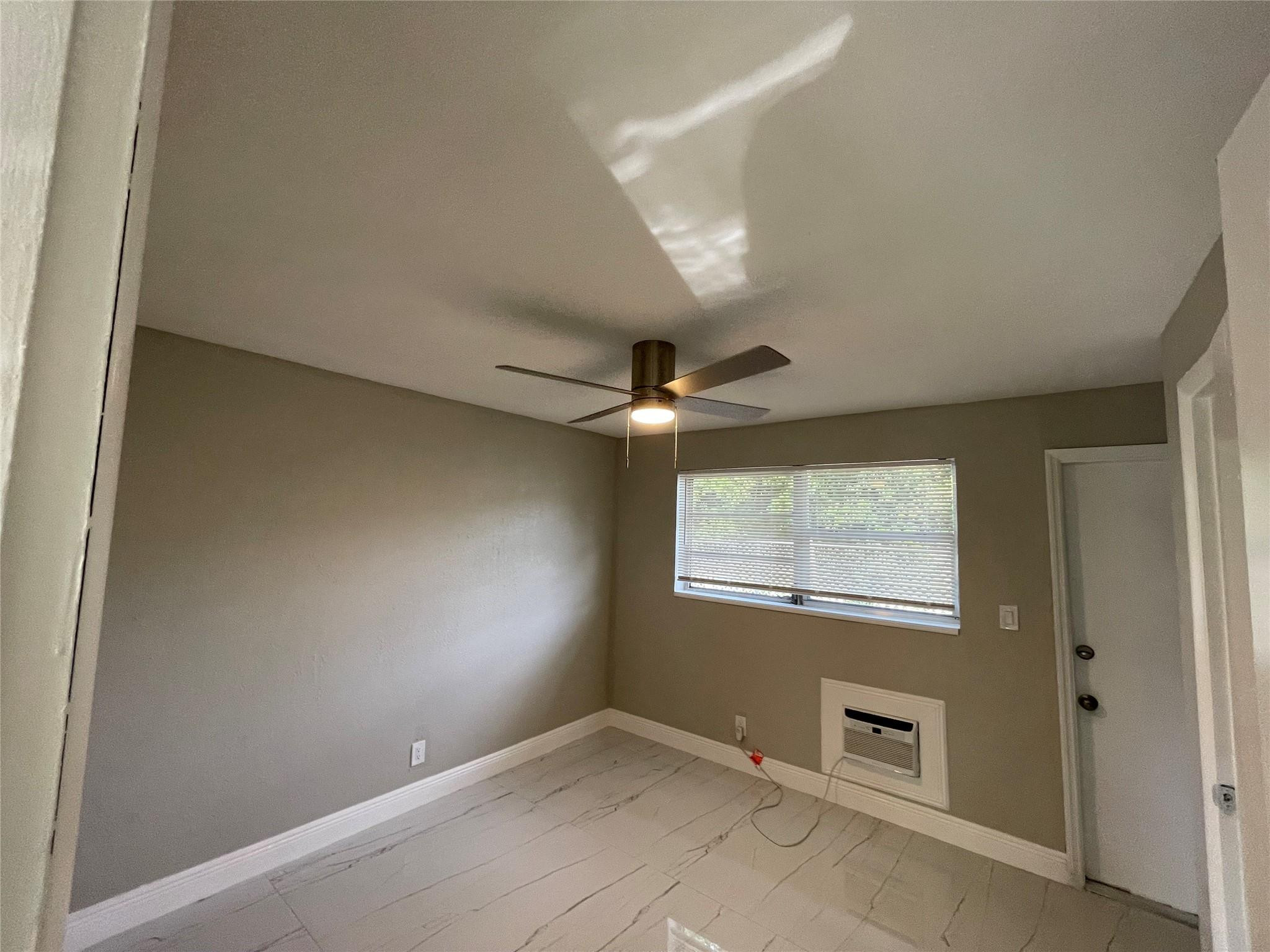 721 Southwest 8th Street Pompano Beach, FL 33060 - Photo 17 of 21 an empty room with windows and fan