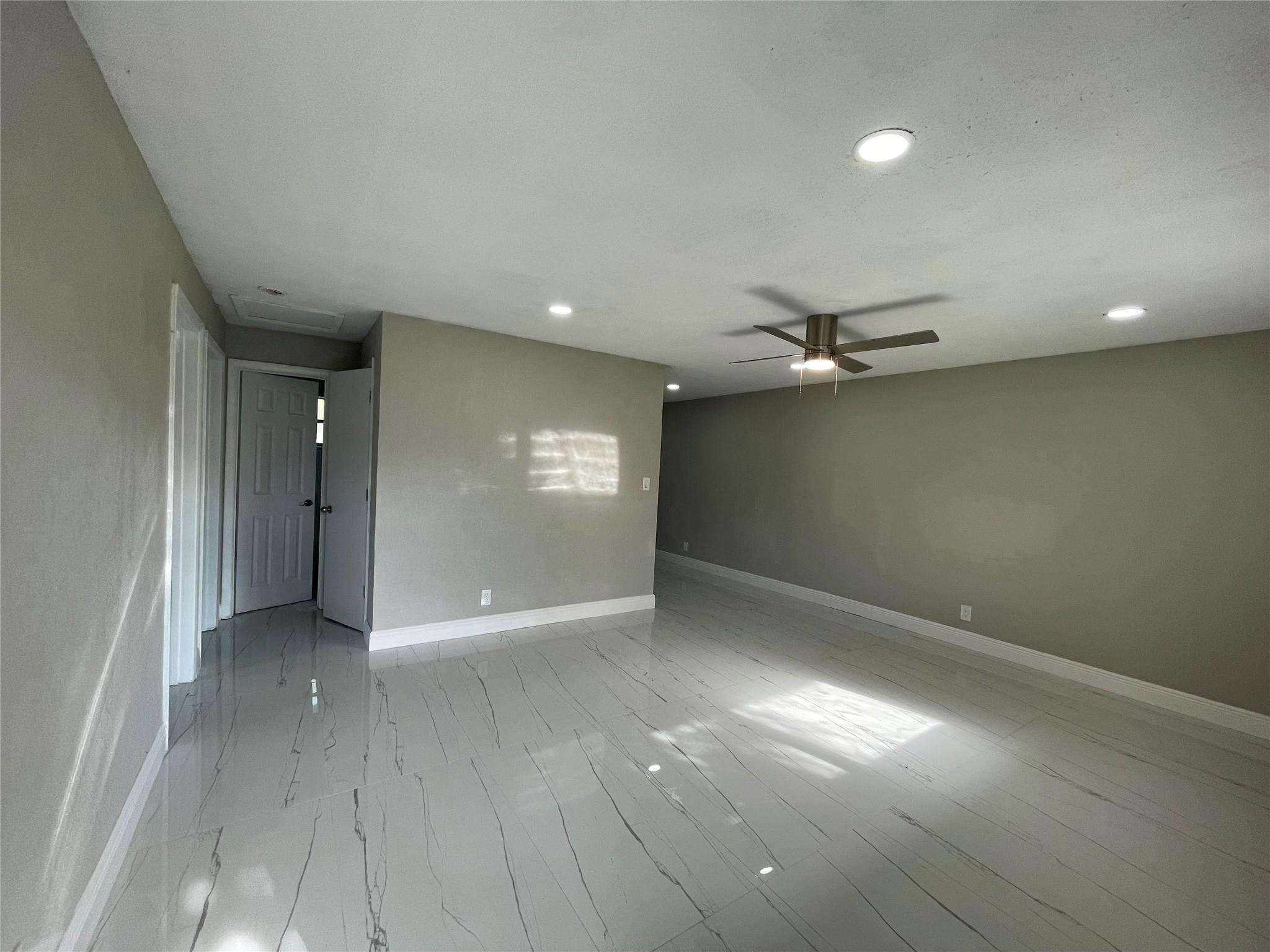 721 Southwest 8th Street Pompano Beach, FL 33060 - Photo 4 of 21 an empty room with wooden floor and windows