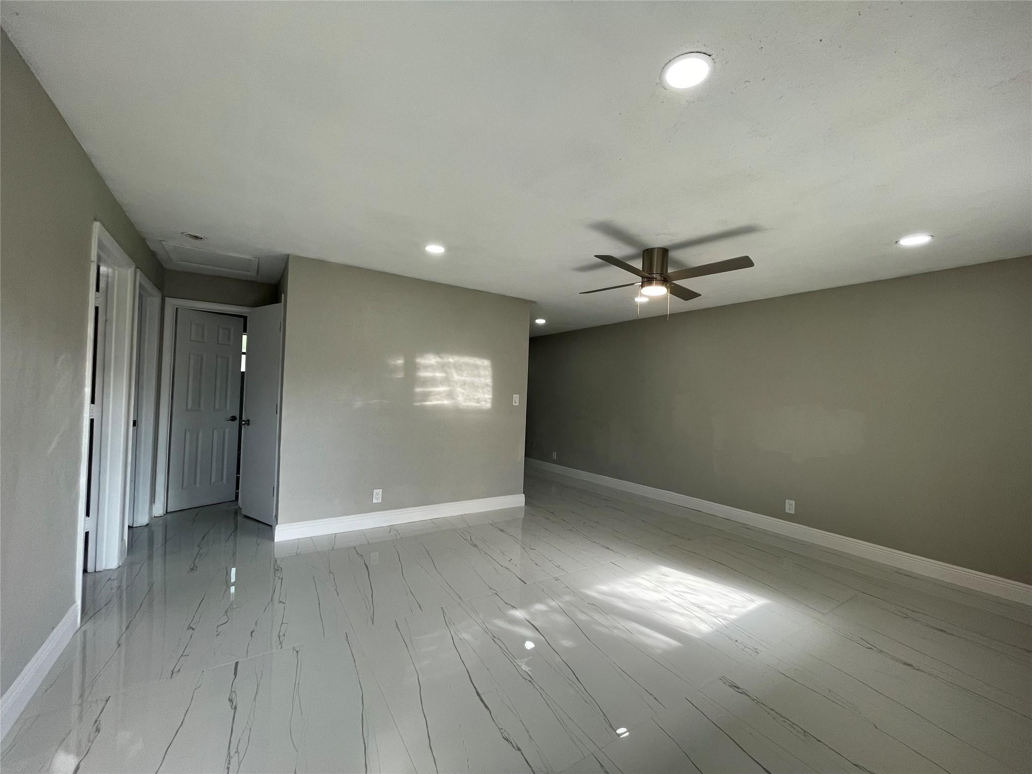 721 Southwest 8th Street Pompano Beach, FL 33060 - Photo 5 of 21 an empty room with wooden floor and windows