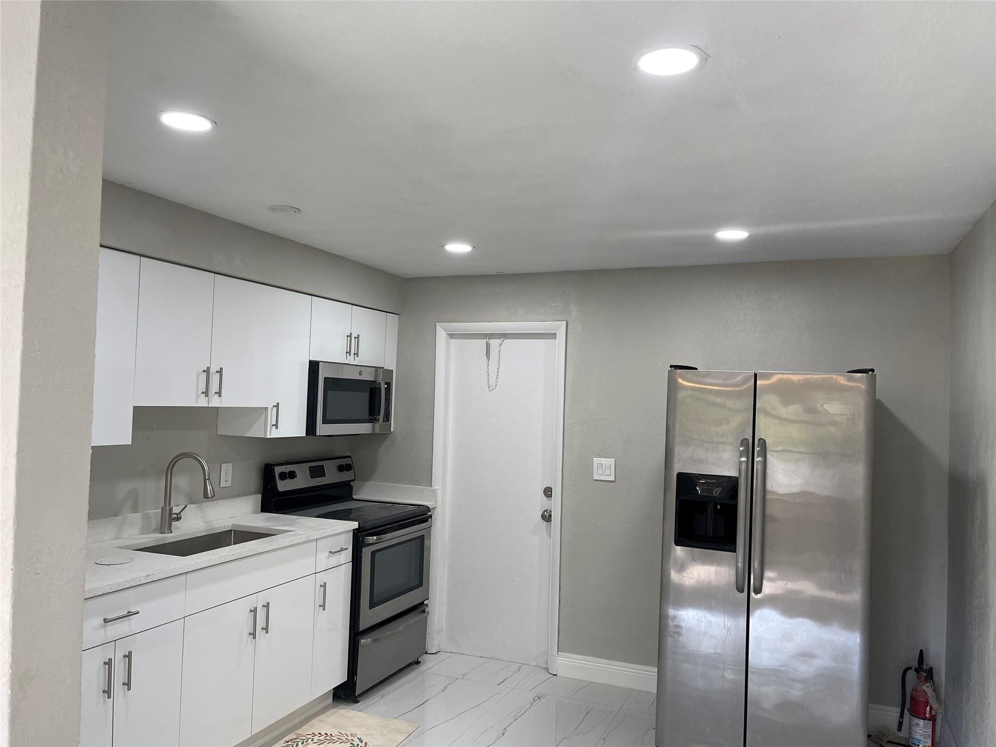 721 Southwest 8th Street Pompano Beach, FL 33060 - Photo 6 of 21 a kitchen with stainless steel appliances a refrigerator sink and microwave