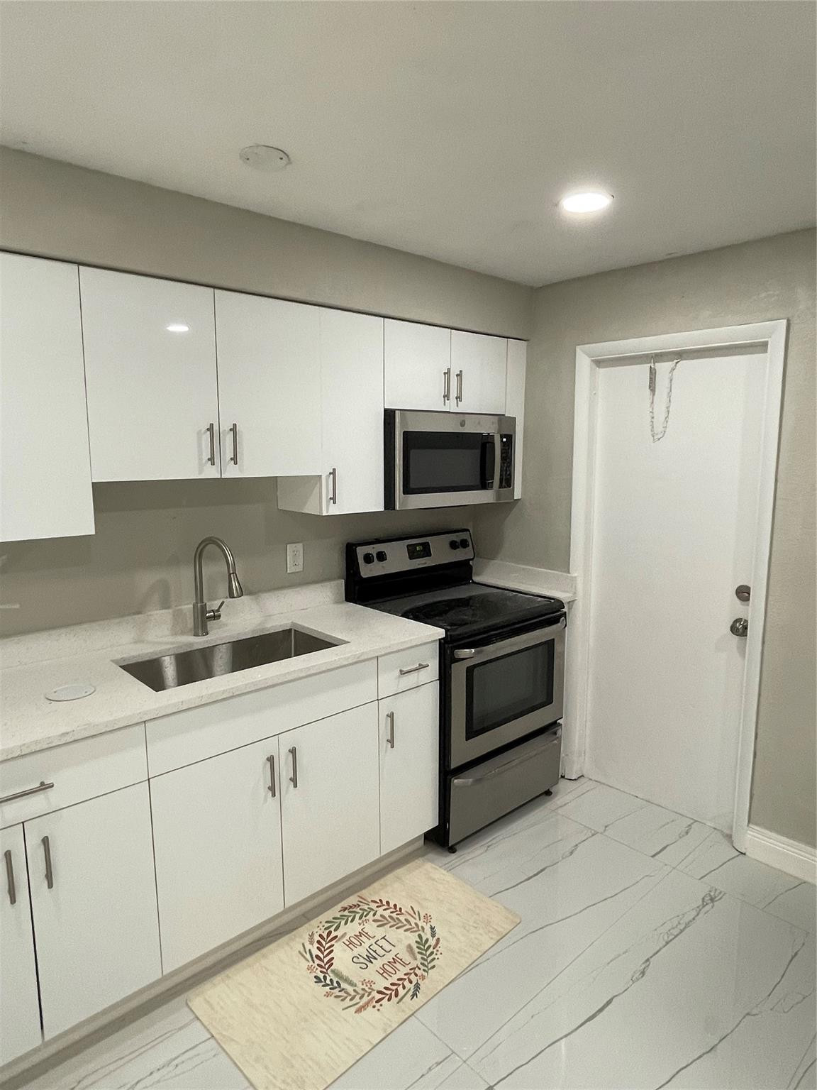 721 Southwest 8th Street Pompano Beach, FL 33060 - Photo 8 of 21 a kitchen with appliances cabinets and a sink