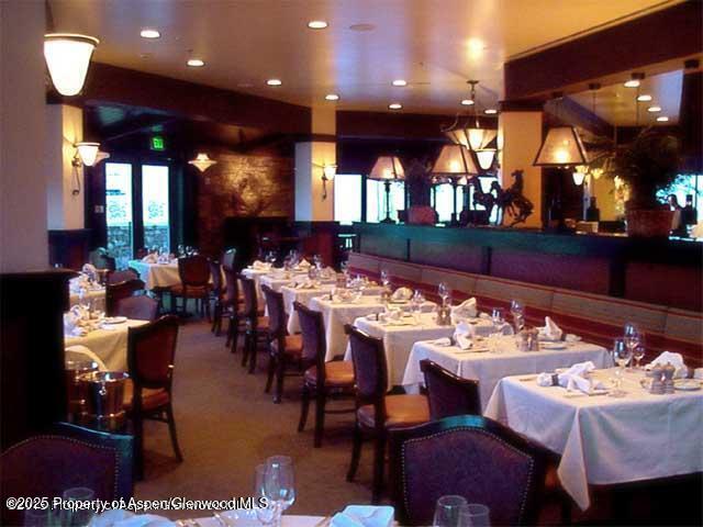 197 Prospector Road, Unit 22052 Aspen, CO 81611 - Photo 19 of 22 a dining hall with furniture a rug and white walls