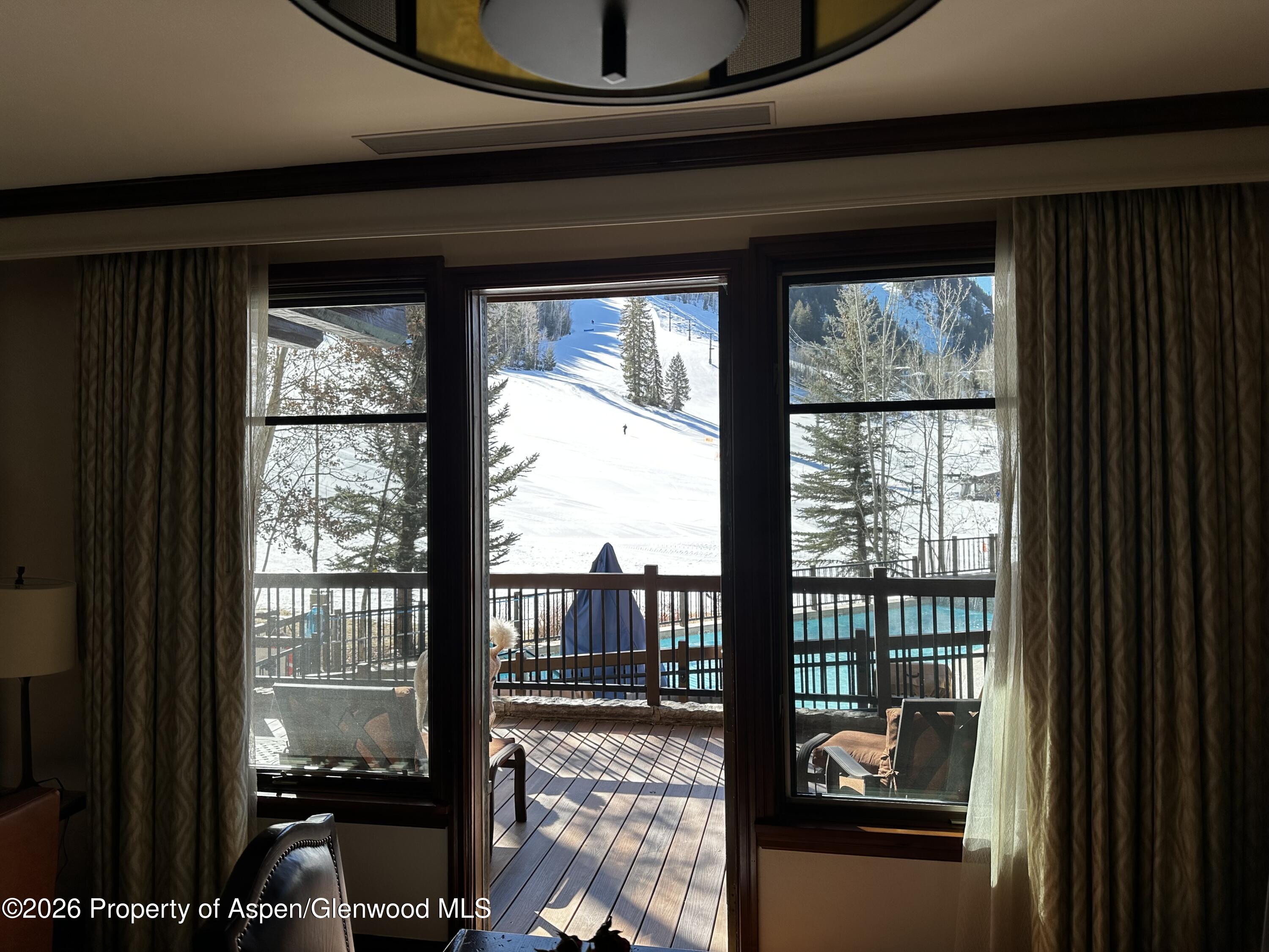 197 Prospector Road, Unit 22052 Aspen, CO 81611 - Photo 6 of 22 a living room filled with furniture and a floor to ceiling window