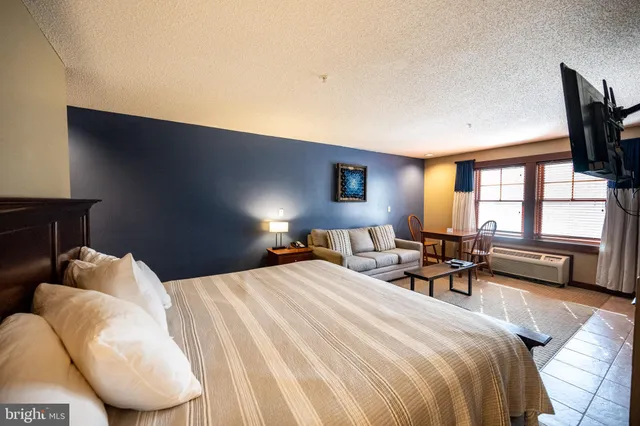 a bedroom with bed and a large window