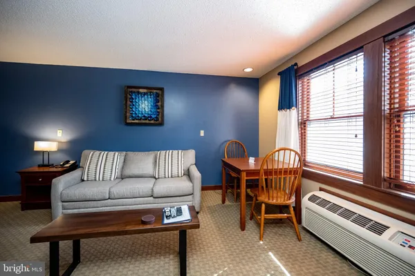 a living room with furniture a lamp and a large window