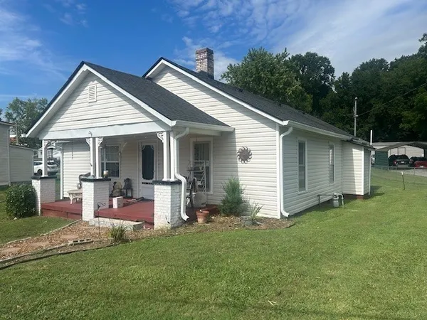 a view of a house with a yard and lawn chairs with plants