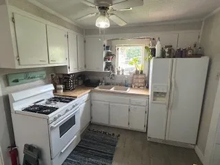 a kitchen with white cabinets and white appliances