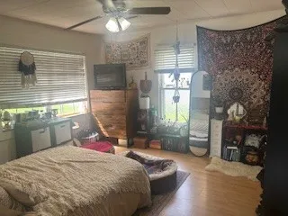 a bedroom with a bed dresser and a window