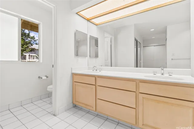 a bathroom with a double vanity sink a toilet and a mirror