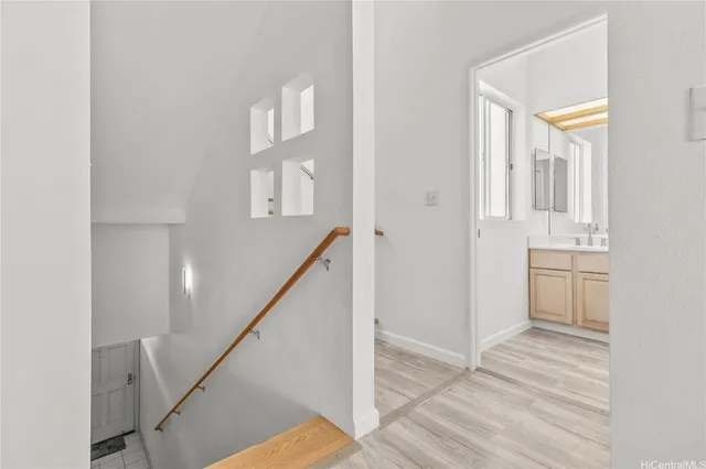 a view of a hallway with wooden floor and staircase