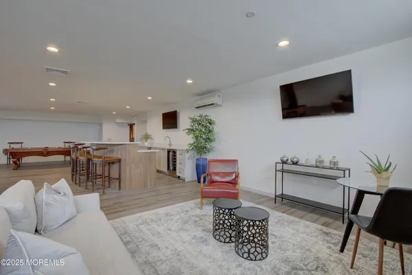 a kitchen with stainless steel appliances granite countertop a stove a refrigerator a sink a dining table and chairs with wooden floor