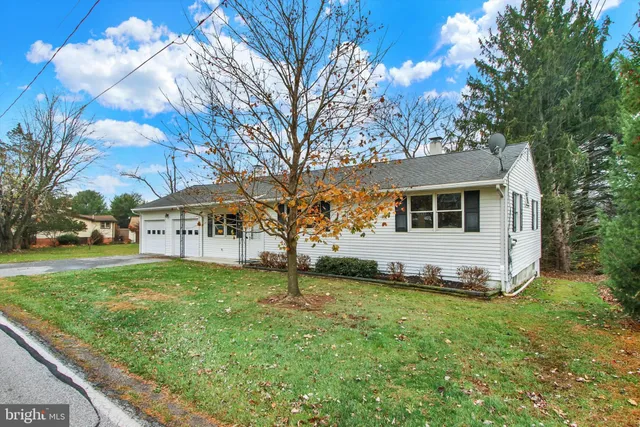 a view of a yard in front of a house with large tree