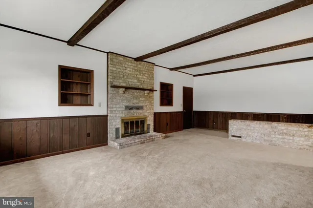 a view of an empty room with a fireplace and a window