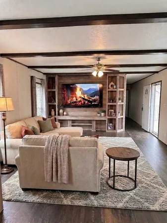 a living room with furniture a flat screen tv and kitchen view