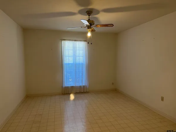 an empty room with chandelier fan