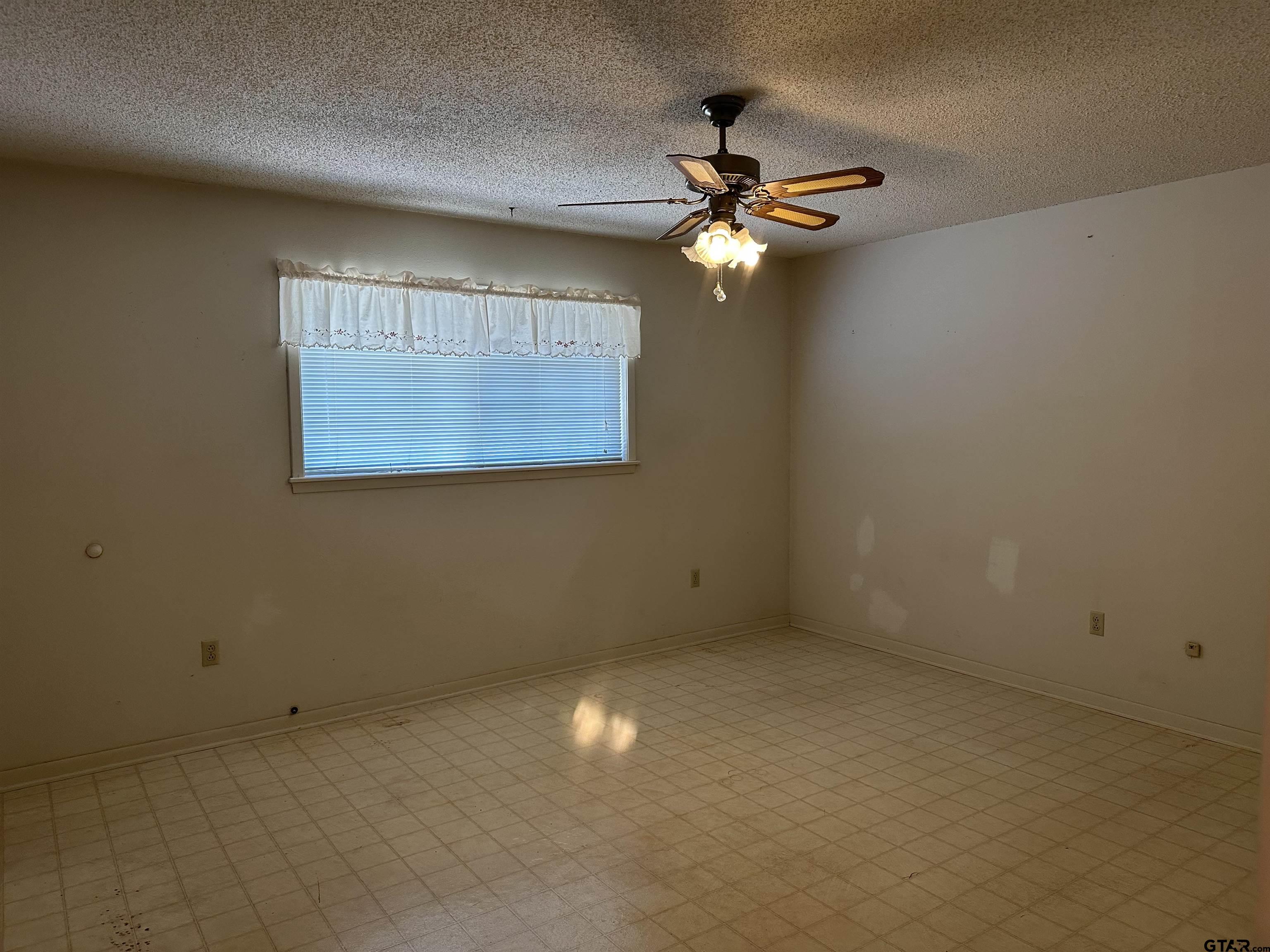 957 Farm To Market 23 Rusk, TX 75785 - Photo 20 of 25 an empty room with a chandelier fan and windows
