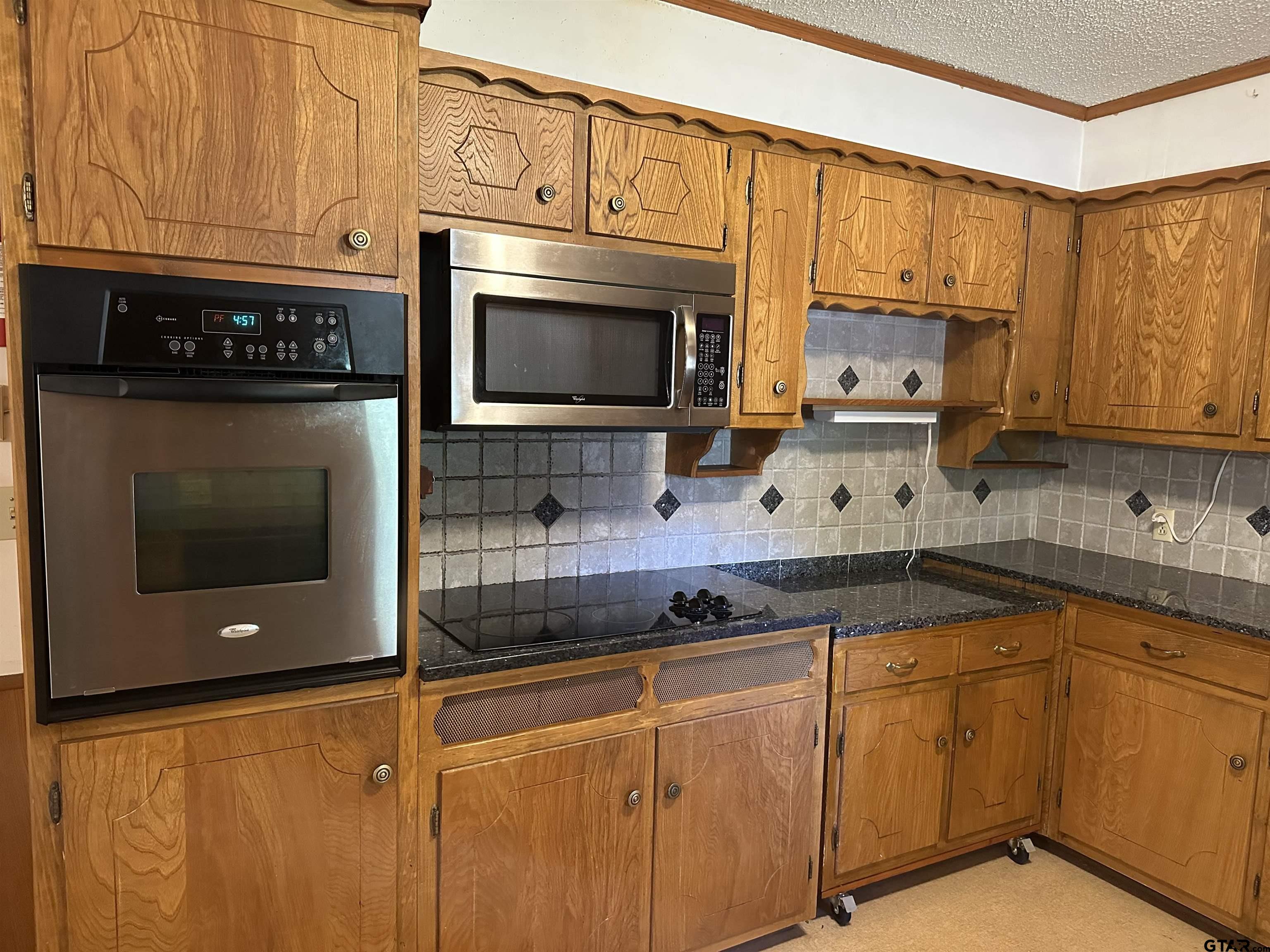957 Farm To Market 23 Rusk, TX 75785 - Photo 7 of 25 a kitchen with stainless steel appliances a stove a microwave sink and cabinets
