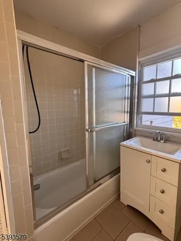 a bathroom with a granite countertop sink mirror and a bathtub