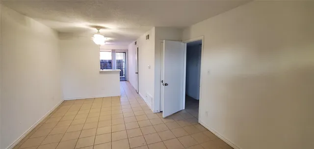 a view of a hallway with wooden floor and a bathroom