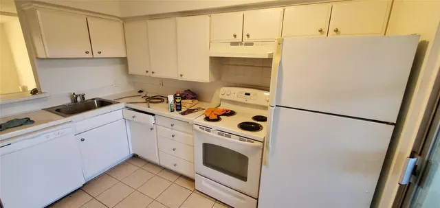 a kitchen with stainless steel appliances a refrigerator sink and cabinets