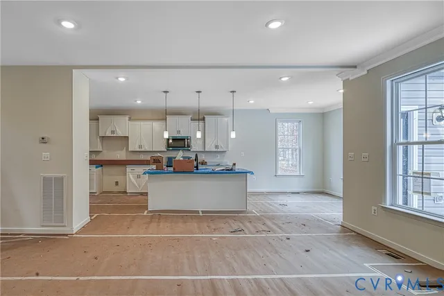 a view of kitchen with stainless steel appliances kitchen island a sink a stove a refrigerator and white cabinets