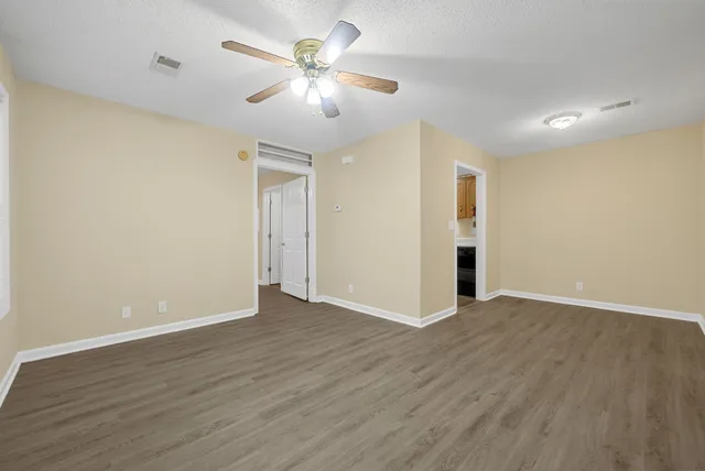a view of an empty room with wooden floor