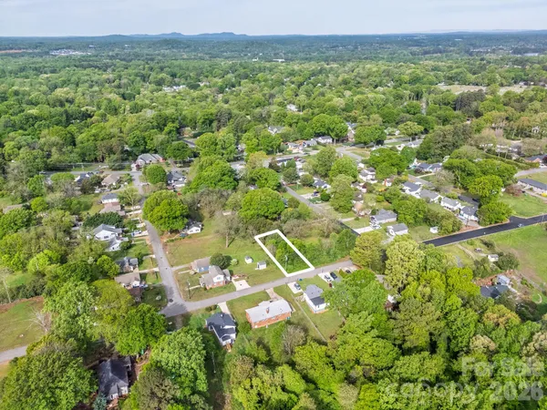 an aerial view of residential houses with outdoor space and trees