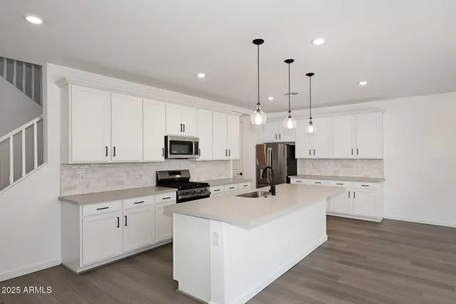 a kitchen with white cabinets and stainless steel appliances