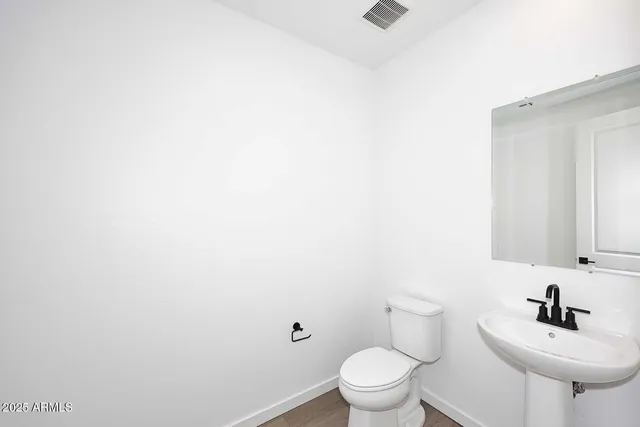 a bathroom with a sink mirror and toilet