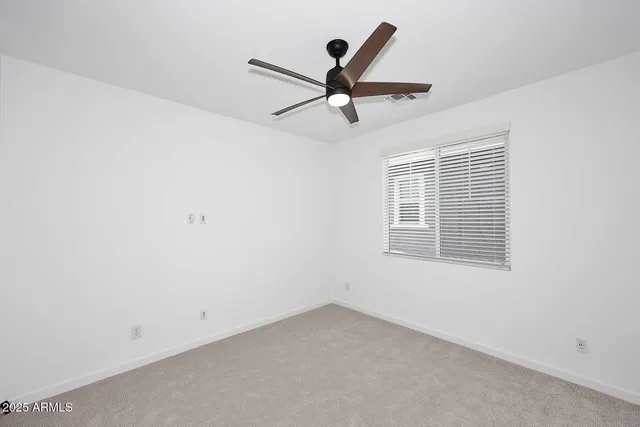 an empty room with a window and a fan