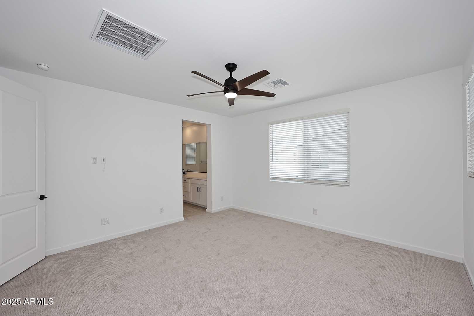 2442 West Rowel Road Phoenix, AZ 85085 - Photo 22 of 55 an empty room with chandelier fan and windows