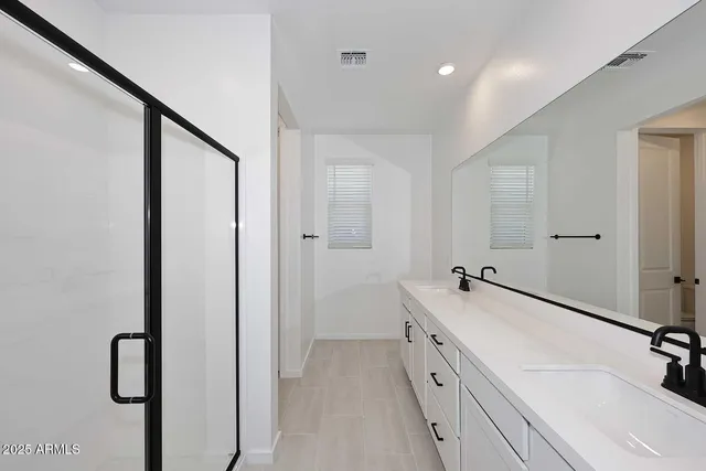 a bathroom with a double vanity sink a mirror and a bathtub