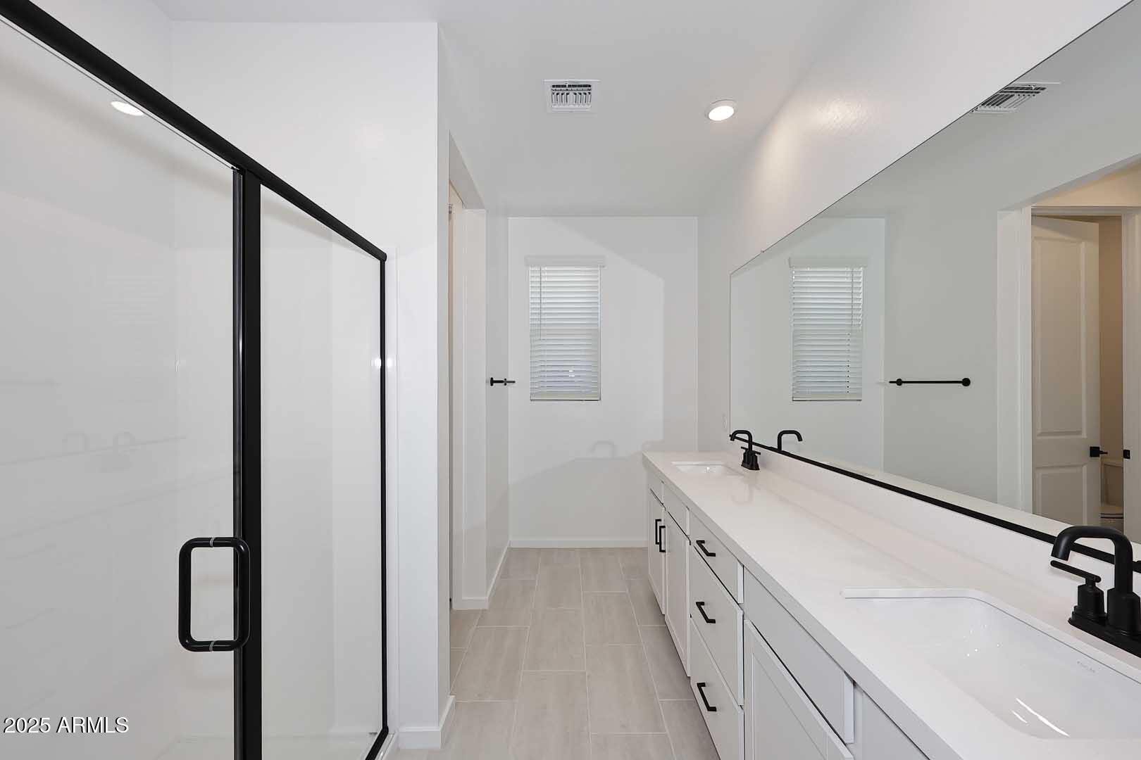 2442 West Rowel Road Phoenix, AZ 85085 - Photo 23 of 55 a bathroom with a double vanity sink a mirror and a bathtub