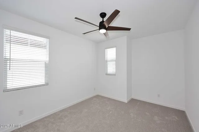 an empty room with a ceiling fan and window