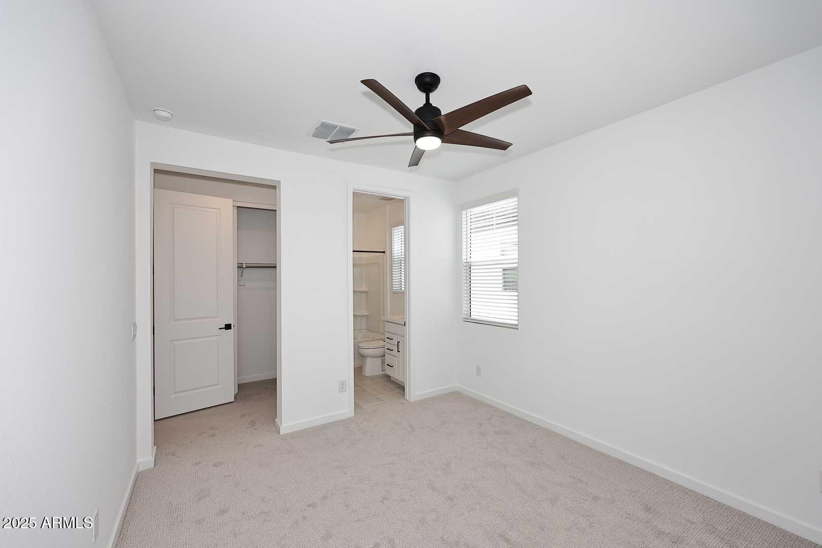 2442 West Rowel Road Phoenix, AZ 85085 - Photo 29 of 55 an empty room with a ceiling fan and window