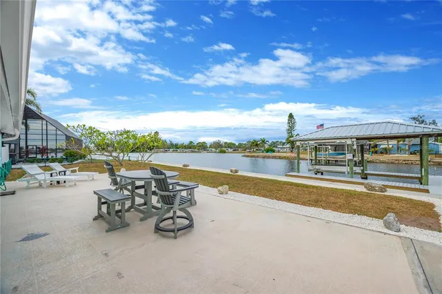a view of a lake with couches and table and chairs